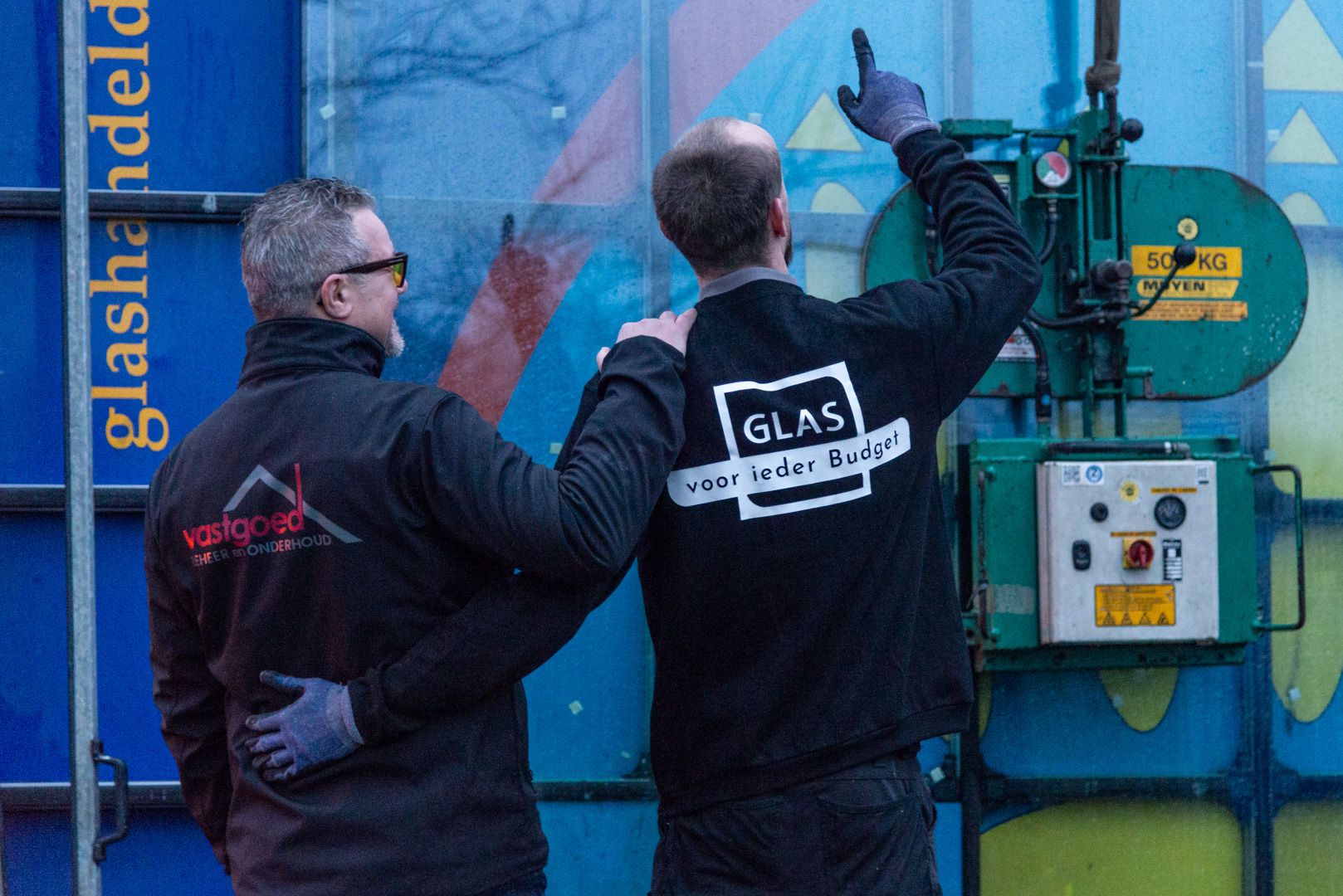 Twee mannen van Glas voor ieder Budget wijzend naar een glasplaat